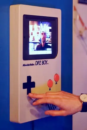 Le Photoboy blanc en fonctionnement, avec une personne qui utilise les commandes d’arcade.